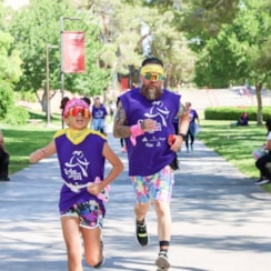 Daughter and dad running, wearing matching shirts, yellow bandanas and reflective sunglasses